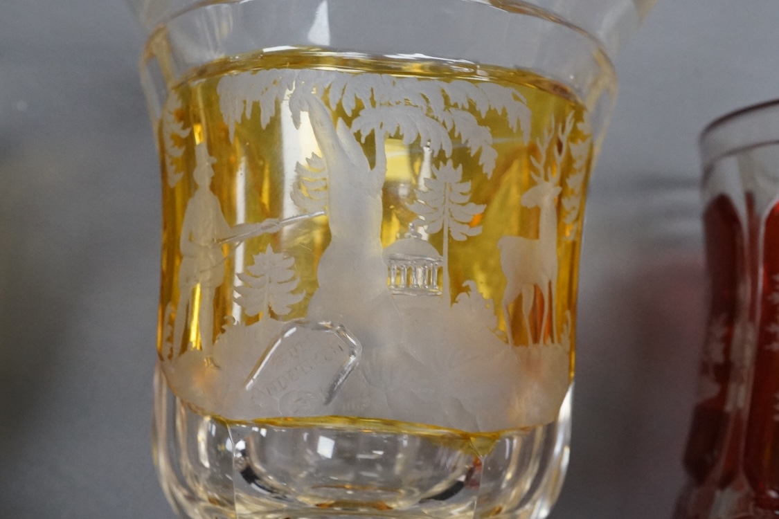 Four Bohemian engraved amber or ruby flashed ‘hunting’ goblets or beakers, late 19th century, tallest 15cm high